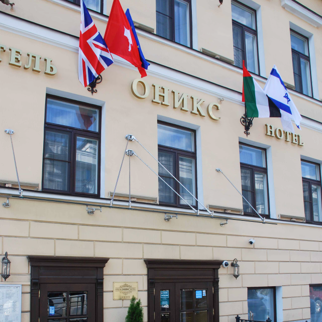 Фото применения фасадных флагштоков на три флага возле отеля Оникс