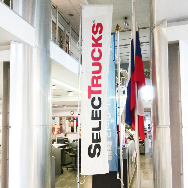 Фото флагштока с баннерным плечом внутри помещения с фиксацией флага к мачте нейлоновыми петлями